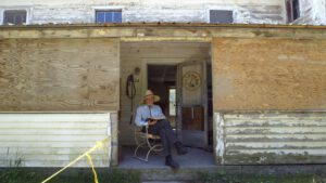 man sitting in front of house